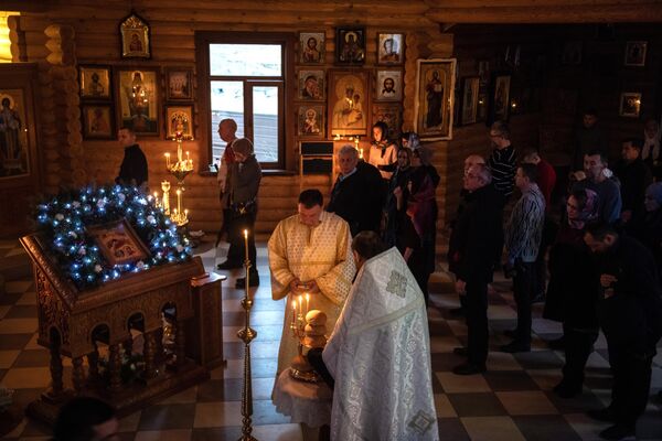 Священнослужители во время Рождественской службы в часовне Покровского храма в Мариуполе