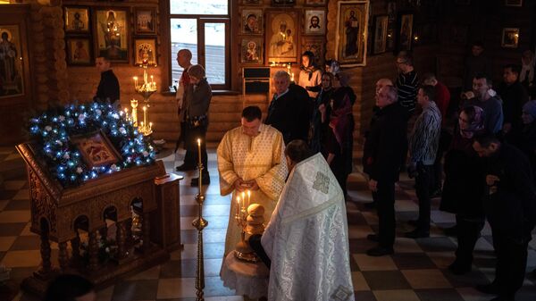 Священнослужители во время Рождественской службы в часовне Покровского храма в Мариуполе