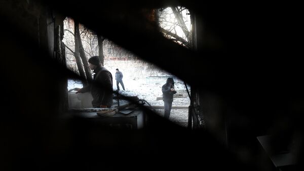 Мужчины у дома, пострадавшего в результате обстрела в Горловке со стороны ВСУ