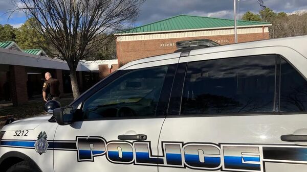 Автомобиль полиции города Ньюпорт-Ньюс на месте стрельбы в начальной школе Ричнек