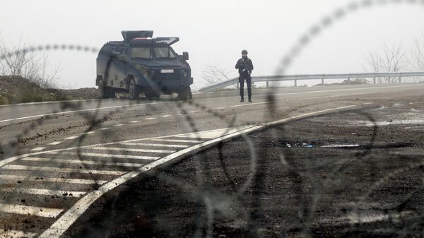 Сотрудники полиции охраняют контрольно-пропускной пункт на косово-сербской границе, Косово