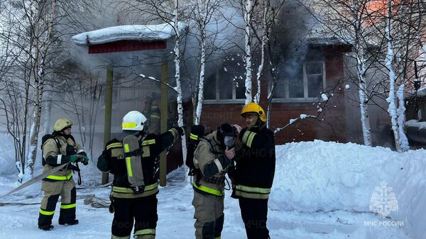 Сотрудники МЧС во время ликвидации пожара в здании общежития в Когалыме, ХМАО