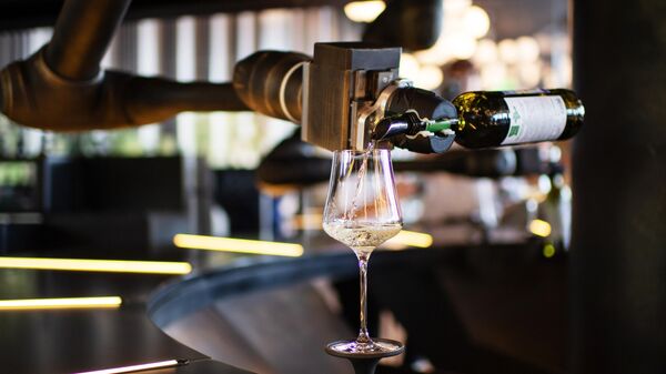 Роботизированный комплекс по обслуживанию гостей наливает вино в бокал в ресторане на территории центра винного туризма Winepark неподалеку от Ялты