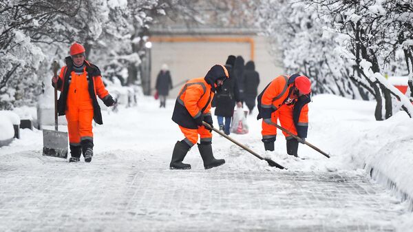 Сотрудники коммунальной службы во время уборки снега