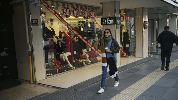 Женщина идет по торговой улице в Анкаре, Турция