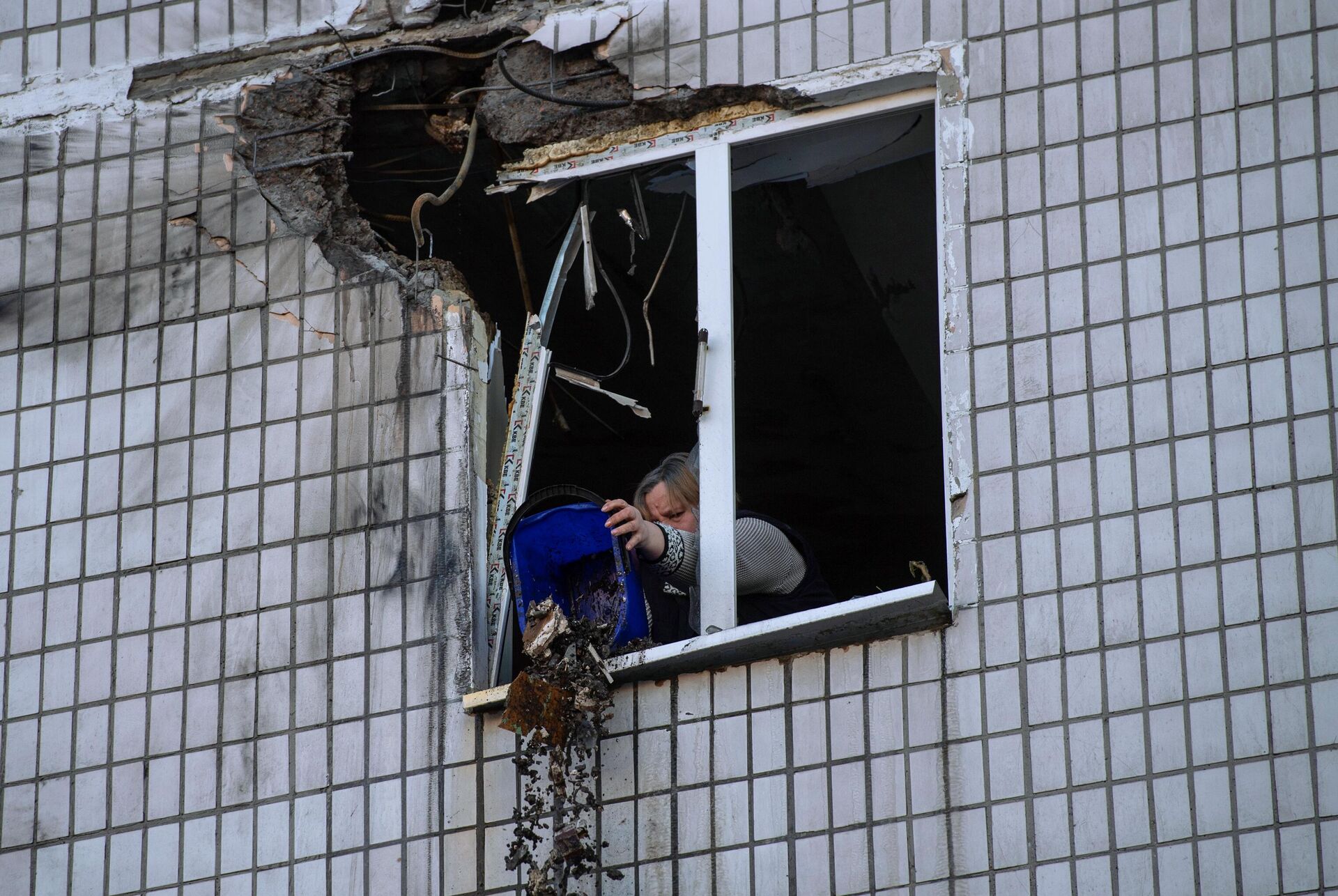 Местная жительница убирается в квартире, пострадавшей в результате обстрела в Петровском районе Донецка - РИА Новости, 1920, 23.01.2023