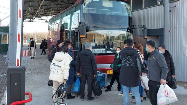 Пассажиры садятся в автобус в пункте пропуска МАПП Краскино в Приморском крае. 10 января 2023