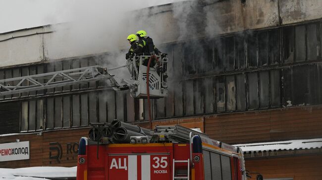 Пожарные во время тушения пожара в автосервисе на улице Добролюбова в Москве