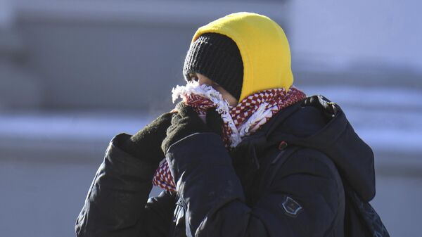 Юноша кутается в шарф на улице в Казани
