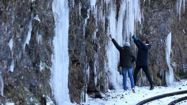 Туристы на узкоколейной железной дороге в Гуамском ущелье, замерзшем из-за сильных морозов, в Краснодарском крае