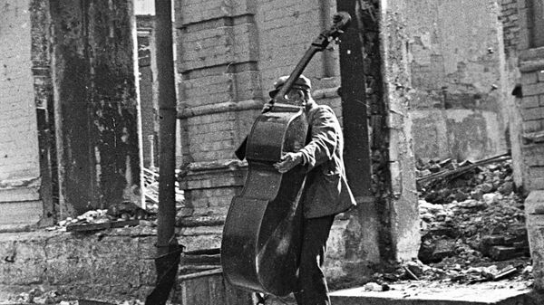 Сталинградская битва (17 июля 1942 г. - 2 февраля 1943 г.). Музыкант на улице разрушенного города.