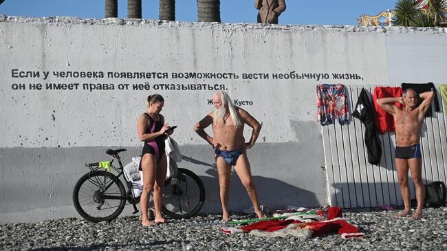 Отдыхающие на галечном пляже у Черного моря в Сочи