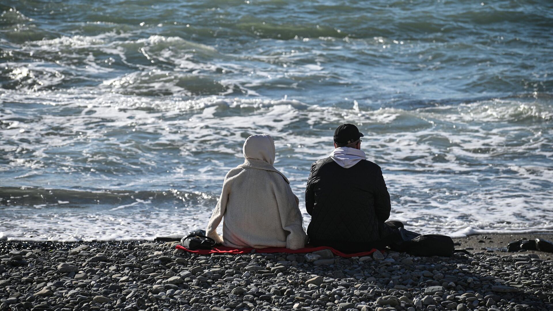 Отдыхающие сидят на галечном пляже у Черного моря в Сочи - РИА Новости, 1920, 26.01.2023