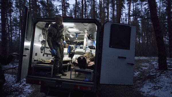 Военный медик эвакуирует раненого украинского солдата
