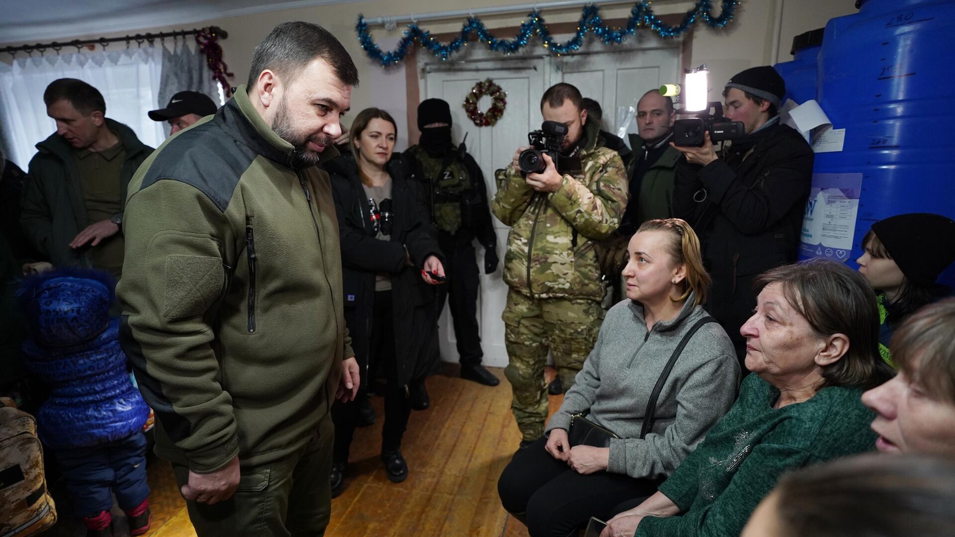 Временно исполняющий обязанности главы Донецкой Народной Республики Денис Пушилин общается с людьми из Соледара в пункте размещения беженцев в Шахтерске - РИА Новости, 1920, 14.01.2023