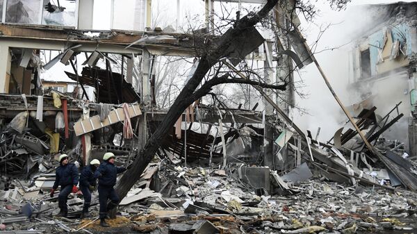 Спасатели на месте разрушенного в результате обстрела со стороны ВСУ торгового здания в Донецке