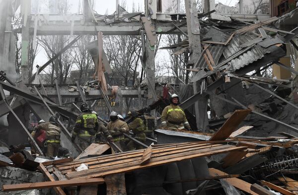 Спасатели на месте разрушенного в результате обстрела со стороны ВСУ торгового здания на проспекте Ильича в Калининском районе Донецка