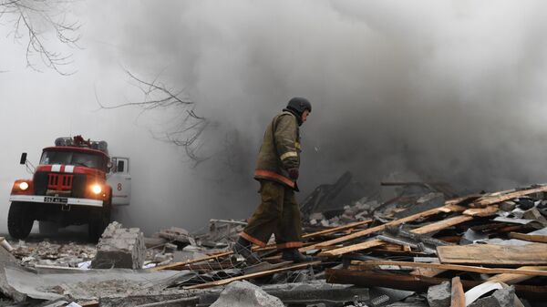 Спасатель на месте разрушенного в результате обстрела со стороны ВСУ торгового здания на проспекте Ильича в Калининском районе Донецка