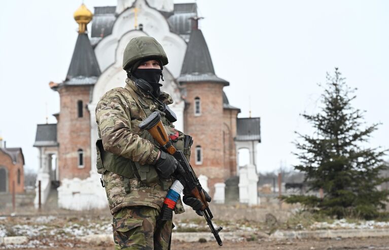 Боец подразделения ЧВК Вагнер в Соледаре. На втором плане – Свято-Преображенский храм.