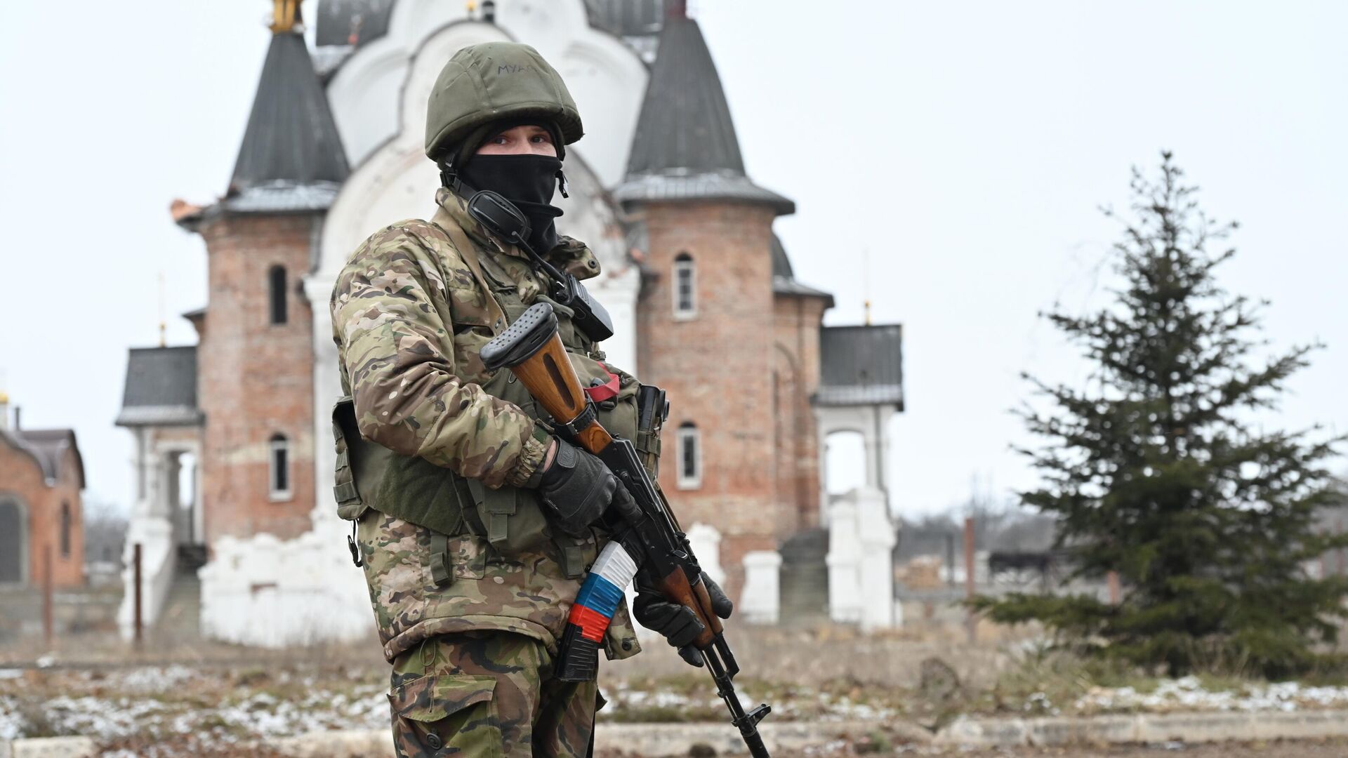 Боец подразделения ЧВК Вагнер в Соледаре. На втором плане – Свято-Преображенский храм. - РИА Новости, 1920, 16.01.2023