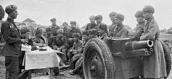 Бойцы артиллерийского подразделения Юго-Западного фронта проводят партийное собрание в короткие минуты затишья между боями. Ноябрь 1943 года.