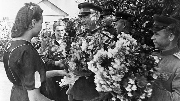 Освобожденные жители латышской деревни преподносят цветы члену Военного Совета II Прибалтийского фронта генерал-лейтенанту Владимиру Николаевичу Богаткину. 1944 год