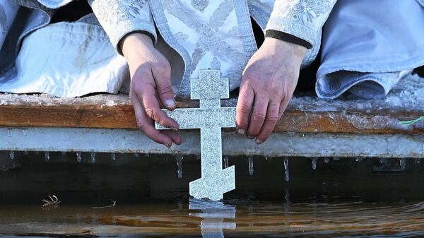 Православный священник освящает иордань в канун праздника Крещения Господня