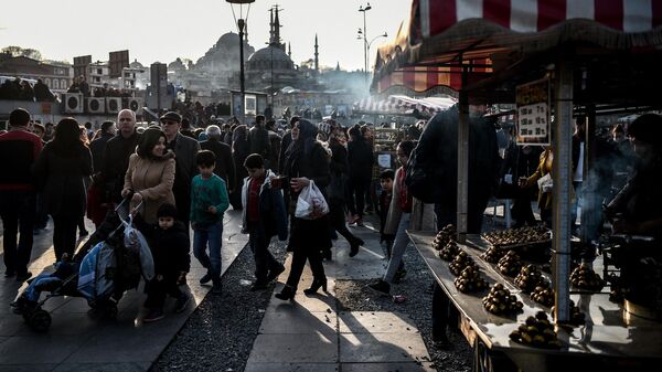 Люди проходят мимо продавца каштанов в районе Эминёню в Стамбуле