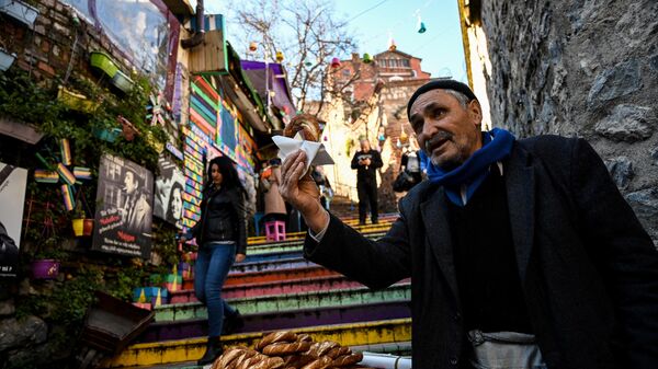 Уличный торговец продает традиционные турецкие бублики Симит в стамбульском районе Балат