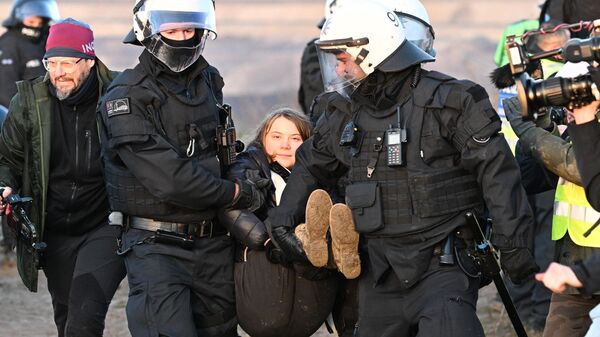 Полицейские уносят шведскую активистку Грету Тунберг с акции протеста против запланированной добычи угля на территории деревни Лютцерат в Германии