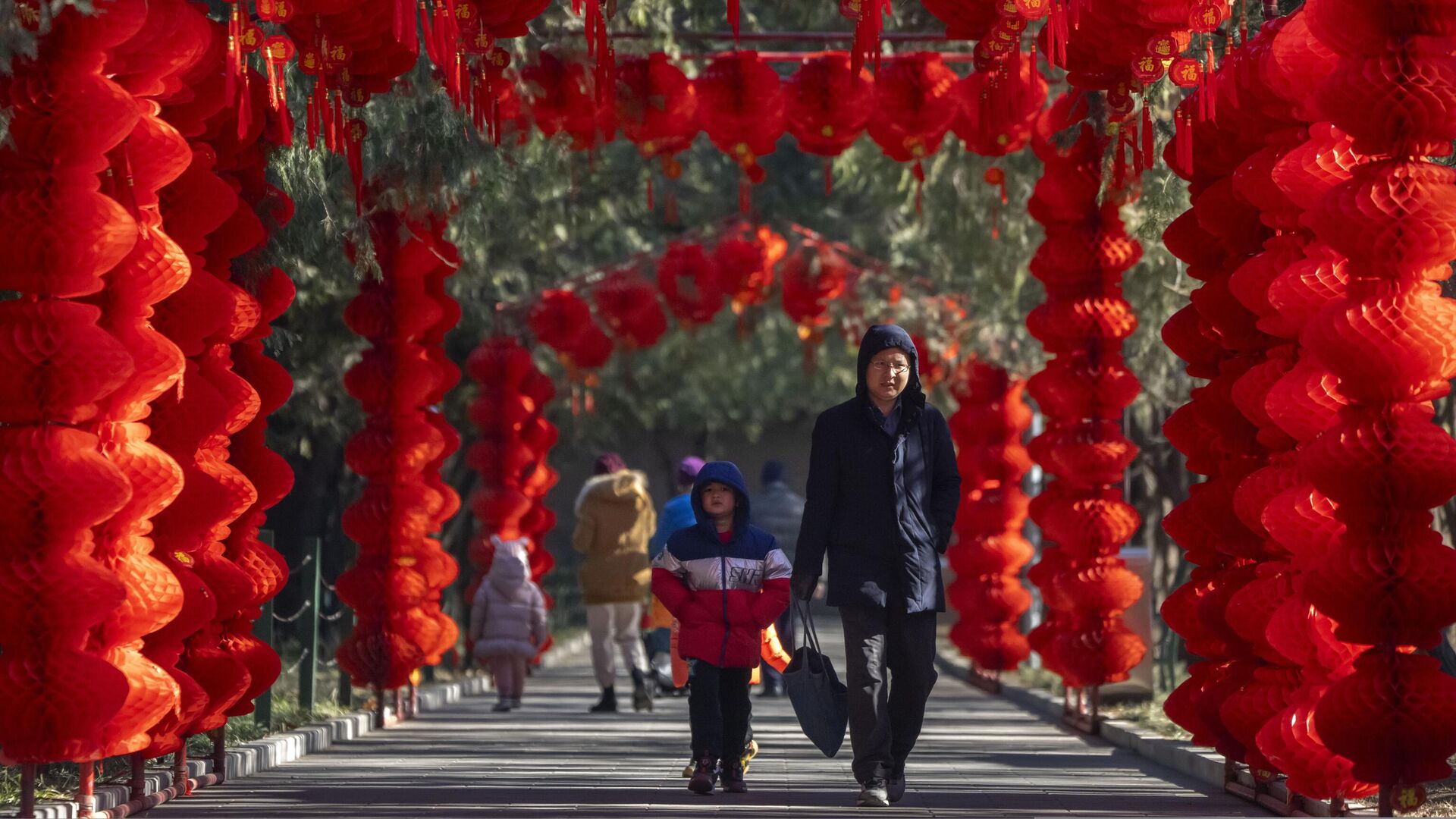 Мужчина и мальчик в общественном парке Пекина, украшенном фонариками в честь наступающего Лунного Нового года — РИА Новости, 1920, 20.01.2023