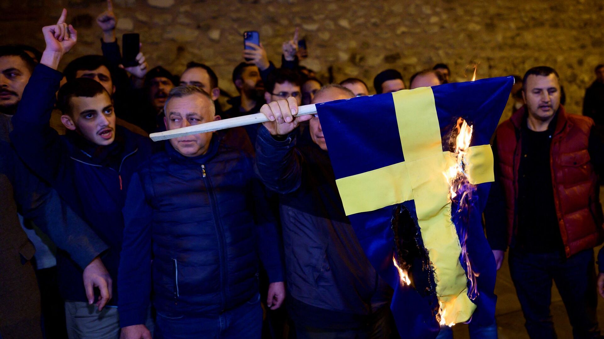 Протестующие сжигают флаг Швеции во время демонстрации перед генеральным консульством страны в Стамбуле - РИА Новости, 1920, 22.01.2023