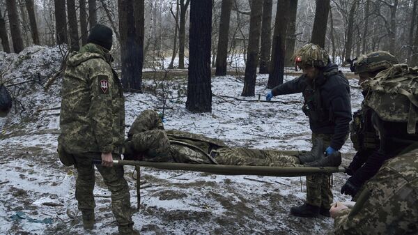 Военные медики несут раненого украинского солдата