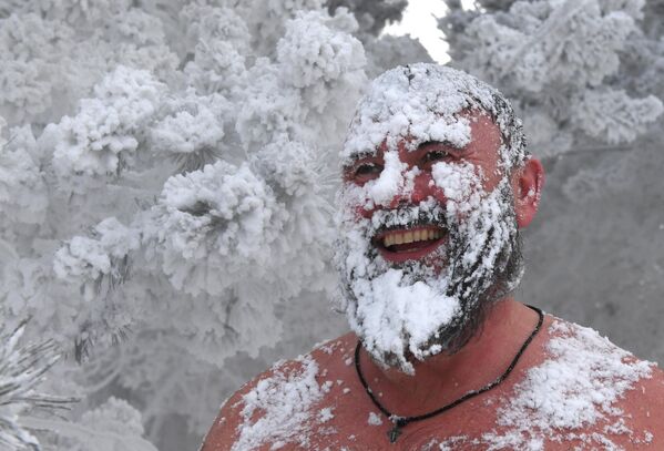 Участник клуба зимнего плавания Криофил обсыпал себя снегом после купания в Енисее при температуре воздуха -35 градусов Цельсия