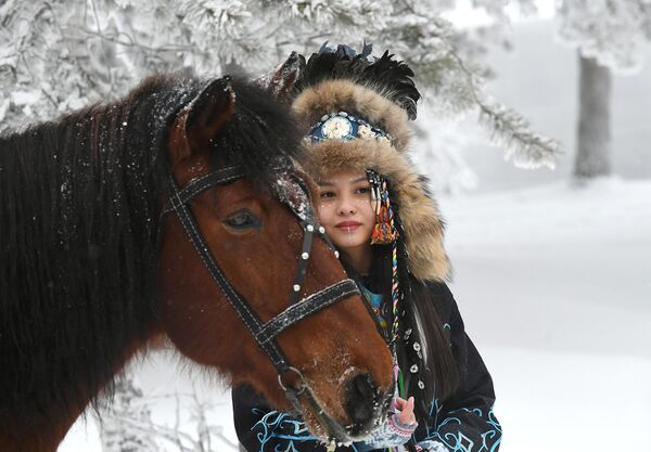 Девушка в стилизованном костюме коренных жителей Сибири на берегу Енисея в окрестностях Красноярска