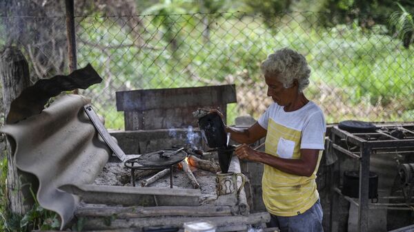 Женщина готовит кофе на ферме, Венесуэла