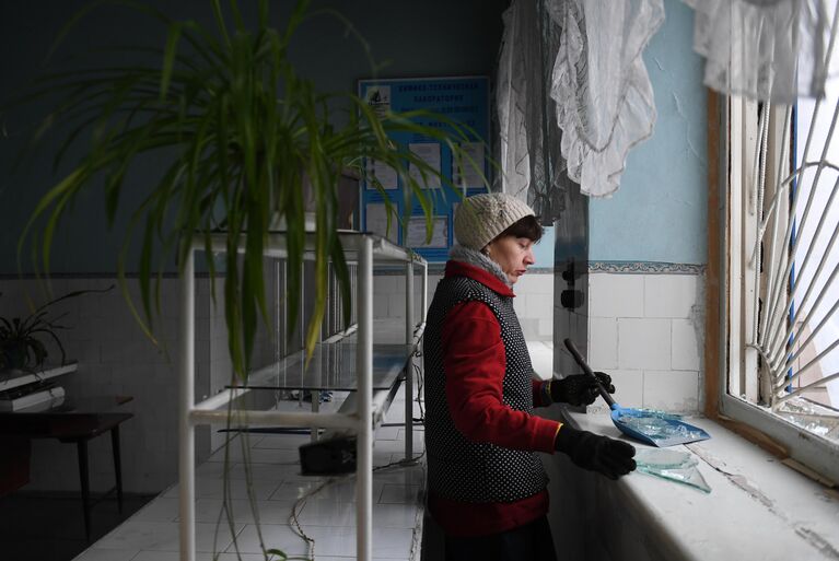 Женщина убирает осколки стекла после обстрела со стороны украинских войск Иловайска Женщина убирает осколки стекла после обстрела со стороны украинских войск Иловайска