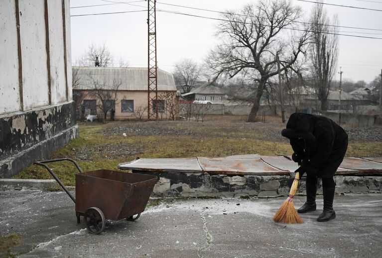 Женщина убирает осколки после обстрела со стороны украинских войск Иловайска Женщина убирает осколки после обстрела со стороны украинских войск Иловайска
