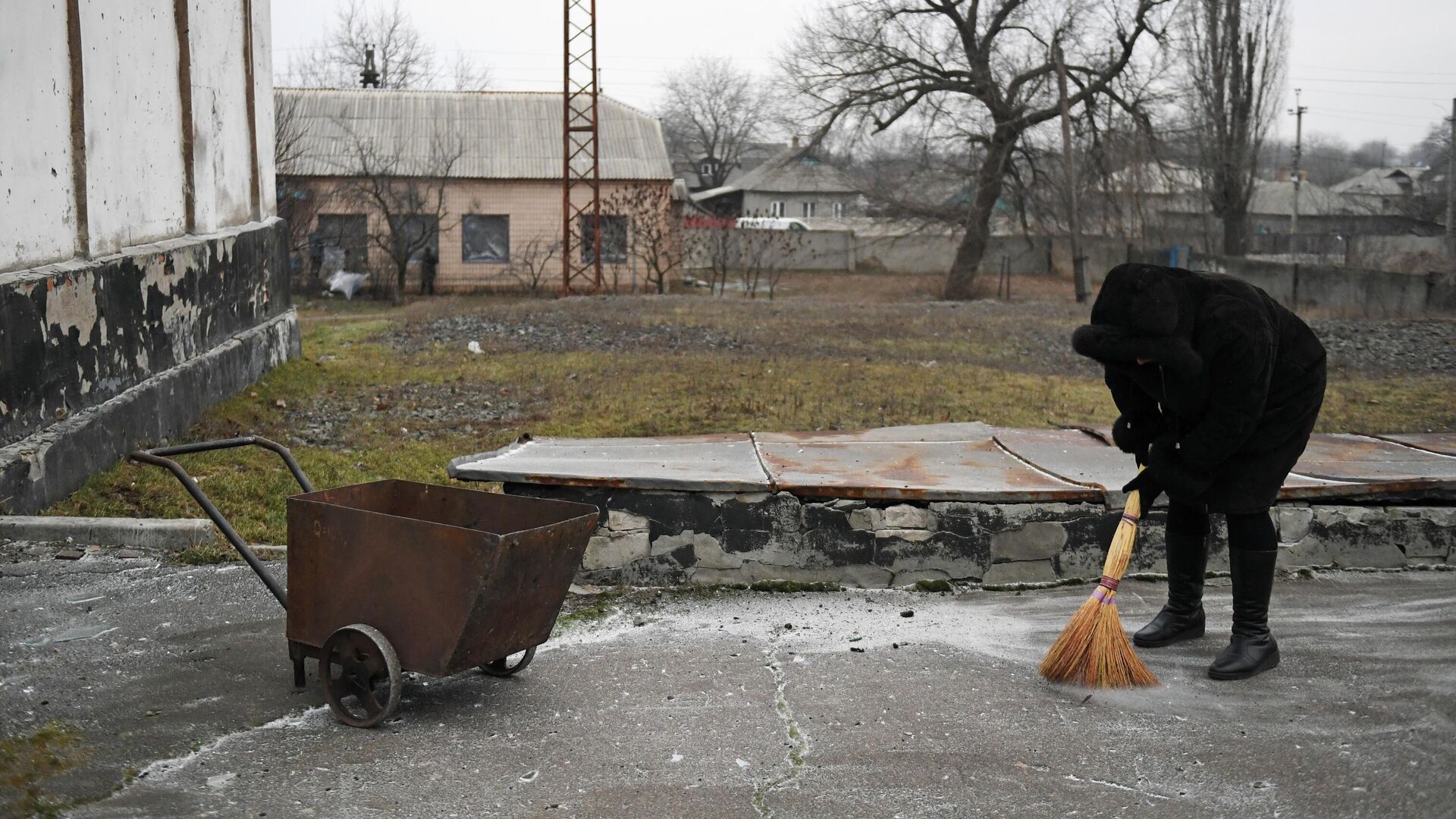 Женщина убирает осколки после обстрела со стороны украинских войск - РИА Новости, 1920, 27.01.2023