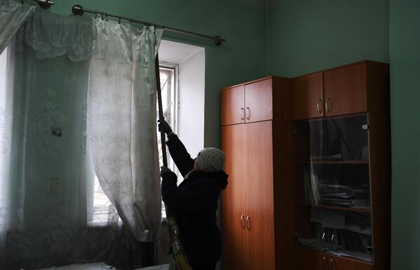 Женщина убирается в здании после обстрела со стороны украинских войск Иловайска