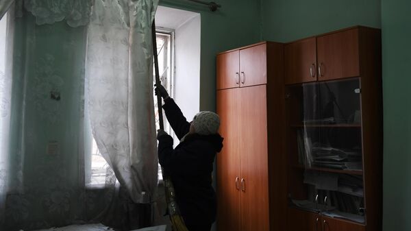 Женщина убирается в здании после обстрела со стороны украинских войск Иловайска