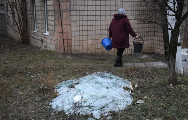 Женщина убирает осколки стекла в одном из зданий после обстрела со стороны украинских войск Иловайска