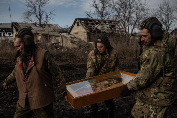 Военнослужащие несут икону после окончания крещенского богослужения на позициях танкистов в ЛНР