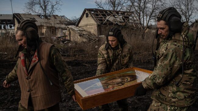 Военнослужащие несут икону после окончания крещенского богослужения на позициях танкистов в ЛНР