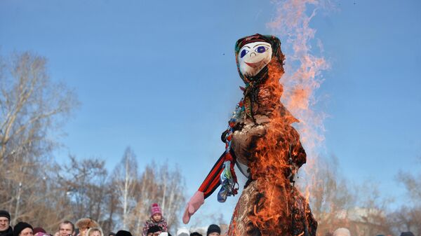 Отдыхающие наблюдают за сожжением чучела Зимы на праздновании Широкой масленицы