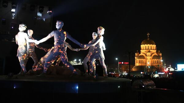 Световые проекции на фигурах скульптурной композиции танцующих детей в Волгограде, созданные в рамках историко-патриотического проекта Мост Памяти