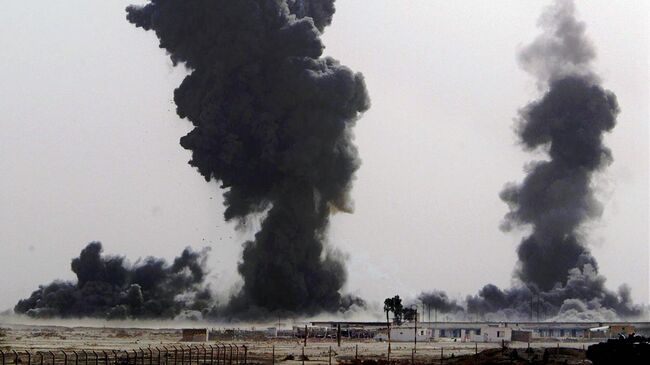 Клубы дыма на иракской военной базе недалеко от южного иракского города Эн-Насирия. 31 марта 2003 года