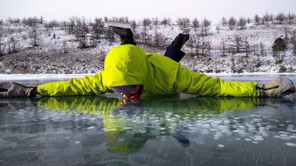Мужчина лежит на замерзшем озере Байкал