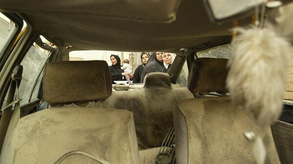 Иракские женщины стоят возле машины, которая была повреждена ракетой, упавшей в жилой район Багдада. 24 марта 2003 год