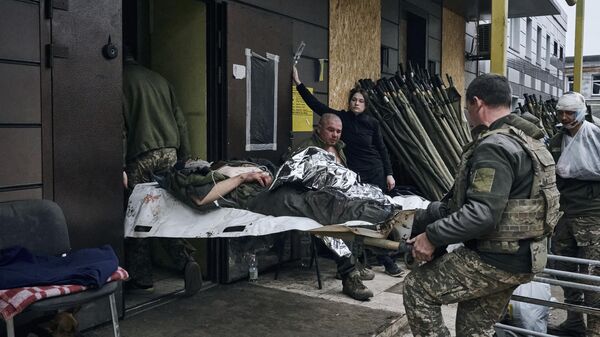 Украинские военные переносят раненого
